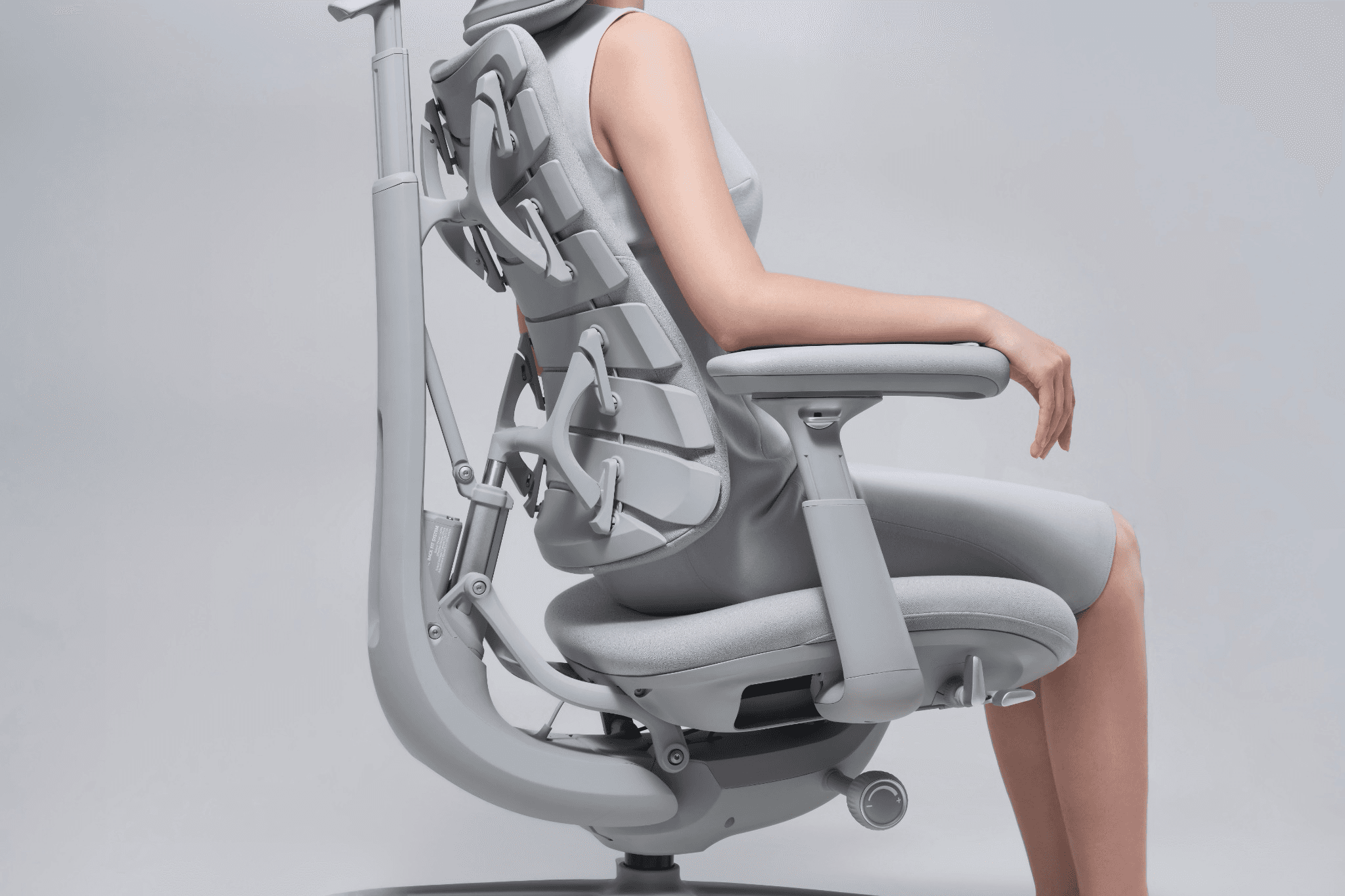 Ergonomic chair supporting a seated person against a light gray background