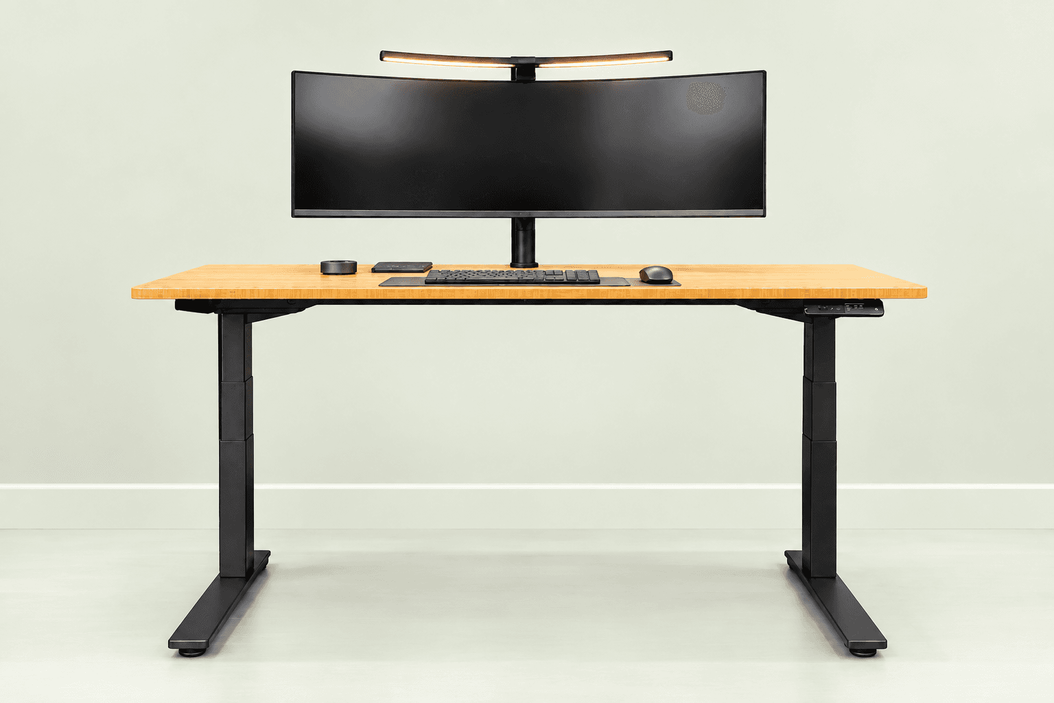 Bamboo sit-stand desk with black legs and an ultrawide monitor